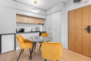 a kitchen and dining room with a table and chairs at Apartament 1 C4 Grand Chalet Poiana Brasov in Braşov