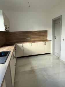 een keuken met witte kasten en een aanrechtblad bij California Home in Odoreu