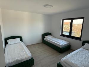 een kamer met twee bedden en een raam bij California Home in Odoreu