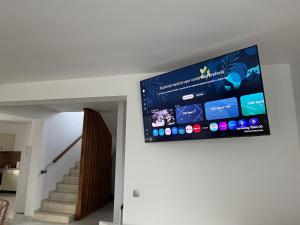een flatscreen-tv aan de muur van een huis bij California Home in Odoreu