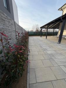 een stenen pad naast een gebouw met rode bloemen bij California Home in Odoreu