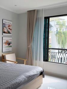 a bedroom with a bed and a large window at Hanique Cafe and Stay in Hanoi