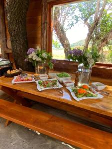 een houten tafel met borden met eten erop bij Hotel Boutique 3 Pasos in Cerro Castillo