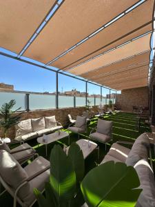 a patio with tables and chairs and a view of the water at Hotel Mounia in Fès