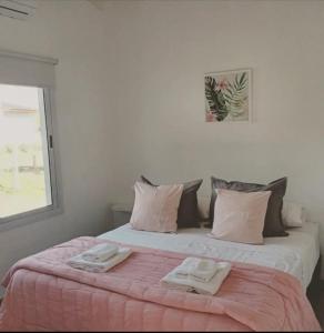 ein Schlafzimmer mit einem Bett, auf dem zwei Handtücher liegen in der Unterkunft Complejo El Caldén in Merlo