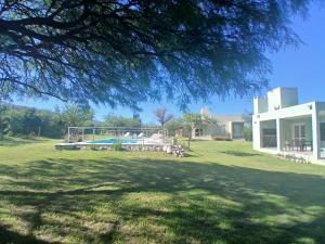 ein großer Garten mit Pool und Haus in der Unterkunft Complejo El Caldén in Merlo