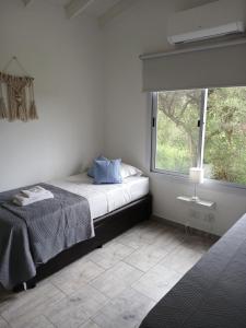 ein Schlafzimmer mit einem Bett und einem großen Fenster in der Unterkunft Complejo El Caldén in Merlo + 10 Fotos
