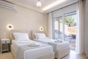 two beds in a room with a window at villa Silda in Atsoupádhes +14 photos