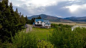een huis op een veld met bergen op de achtergrond bij Hotel Boutique 3 Pasos in Cerro Castillo +46 foto's