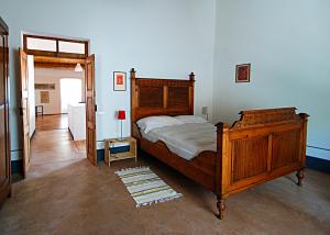 een slaapkamer met een houten bed in een kamer bij Asino Nero in Milis