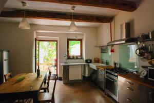 een keuken met een houten tafel en een eetkamer bij Asino Nero in Milis