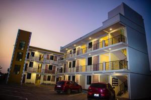 zwei Autos auf einem Parkplatz vor einem Gebäude geparkt in der Unterkunft Georgina's Court in Trofwi