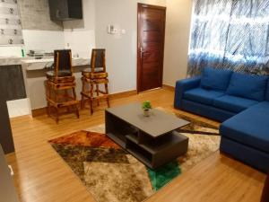 ein Wohnzimmer mit einem blauen Sofa und einem Tisch in der Unterkunft Georgina's Court in Trofwi