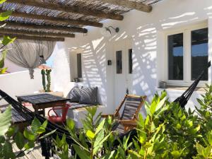 un patio con sedie e un tavolo in una casa di Casa Poente - Casas de Seixe a São Teotónio