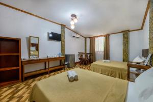a hotel room with two beds and a tv at El Nido Viewdeck Cottages in El Nido +20 photos