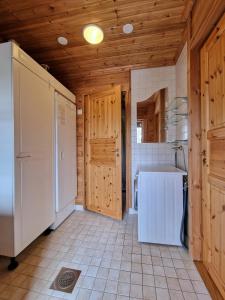 a kitchen with a refrigerator and a washer and dryer at Pääsiäiskuru 3 in Kakslauttanen +4 photos