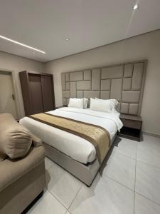 een slaapkamer met een groot bed en een bank bij شقق طلال الفندقية- Talal hotel apartments in Al Ula