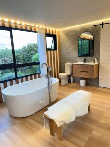 a bathroom with a tub and two toilets and a sink at 007 Loft in Mossel Bay +13 photos