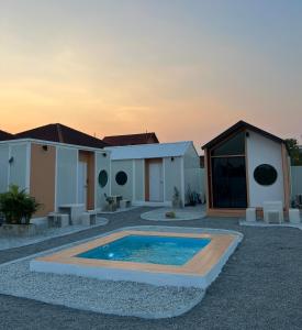 een huis met een zwembad in een tuin bij JAYLA Resort in Sattahip