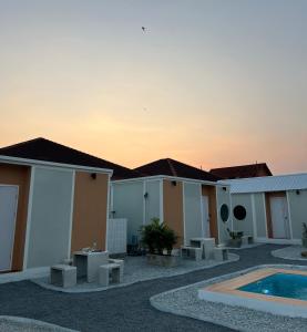een rij huizen met een zwembad en een zonsondergang bij JAYLA Resort in Sattahip