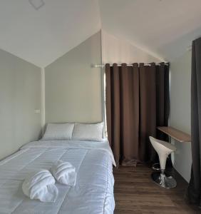 een slaapkamer met een bed met twee handdoeken erop bij JAYLA Resort in Sattahip +23 foto's