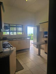 een keuken met witte kasten en een aanrechtblad bij Maja Hzari in Densainagar