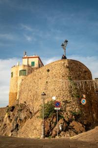een gebouw bovenop een stenen muur bij Guest House - Appusentu in Castelsardo