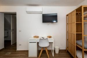 a bedroom with a desk with a chair and a tv at Guest House - Appusentu in Castelsardo