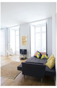 ein Schlafzimmer mit einem Bett in einem Zimmer mit Fenstern in der Unterkunft Residencial Neves - Baixa in Lissabon