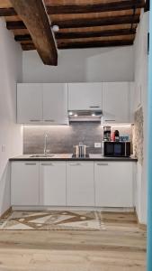 een keuken met witte kasten en een spoelbak bij La Casetta di Cri in Todi +18 foto's