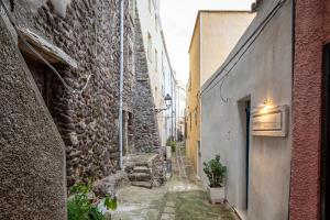 een steegje tussen twee gebouwen in een oude stad bij Guest House - Appusentu in Castelsardo