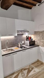 een keuken met witte kasten en een spoelbak bij La Casetta di Cri in Todi