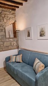 een blauwe bank in een woonkamer met een stenen muur bij La Casetta di Cri in Todi