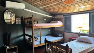 a room with two bunk beds and a mirror at Casa Lee Hostel in Paraty