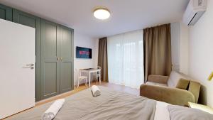 a bedroom with a bed and a couch and a table at NEW Studio by Nivy & Bus Station w AC in Bratislava