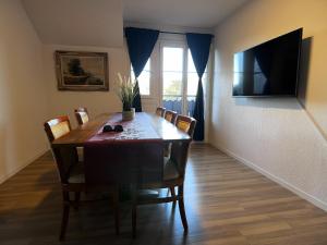 a dining room table with chairs and a television at Apartment Spiez - Lake view - for 7 guests in Thun