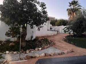 un vialetto di una casa con un albero e delle rocce di Villa Verzul a Lobres