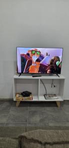 una TV a schermo piatto seduta sulla mensola di Nuestra Casa en Paso a Paso de la Patria