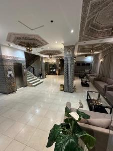 a lobby with couches and a staircase in a building at Hotel Mounia in Fès