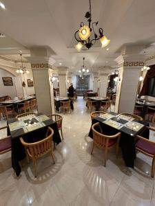 a restaurant with tables and chairs and a chandelier at Hotel Mounia in Fez