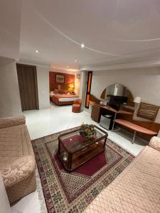 a living room with a couch and a bed and a table at Hotel Mounia in Fès