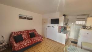 a living room with a red couch and a refrigerator at Studio Emilie in Balaruc-les-Bains