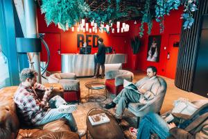 a group of men sitting in chairs in a room at Radisson RED Hotel, Vienna in Vienna