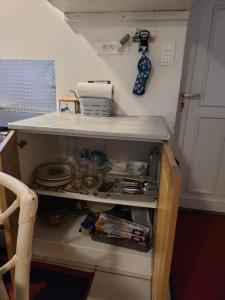 ein Küchenregal mit Geschirr und eine Arbeitsplatte in der Unterkunft À la campagne, studio 25m2-pour 2 au calme, wifi, jardin, parking in Yèvres + 19 Fotos