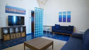 een woonkamer met een blauwe bank en een tv bij BlueBlu Apartment in Brindisi