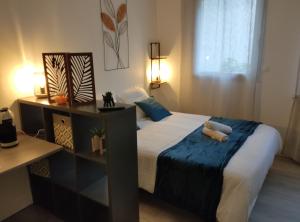 een slaapkamer met een groot bed met een blauwe deken bij Villa Raphaëlle #3 Centre ville avec parking in Le Havre