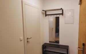 een witte kamer met een deur en een spiegel bij Apartments Kellergasse in Purbach am Neusiedlersee