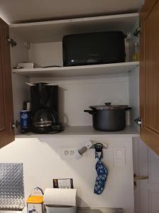 eine Krawatte, die in einer Küche auf einem Regal hängt in der Unterkunft À la campagne, studio 25m2-pour 2 au calme, wifi, jardin, parking in Yèvres