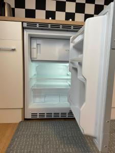een lege koelkast met de deur open in een keuken bij Studio apartment - Park view in Thun