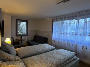 een slaapkamer met een bed, een stoel en een raam bij Studio apartment - Park view in Thun